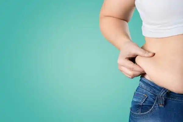 Image of woman pinching her love handles to show weight gain Huddersfield